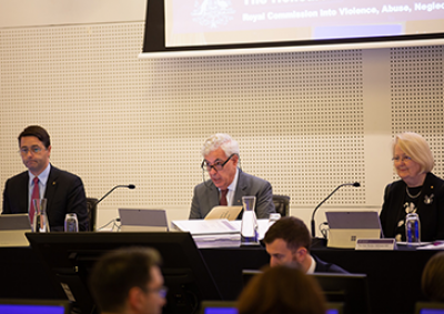 Three commissioners conducting a public hearing in a courtroom