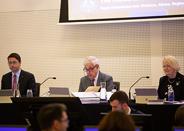 Three commissioners conducting a public hearing in a courtroom