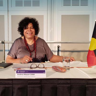 Commissioner Andrea Mason OAM seated at desk